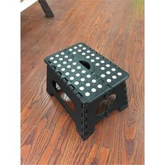 a black and white stool sitting on top of a wooden floor