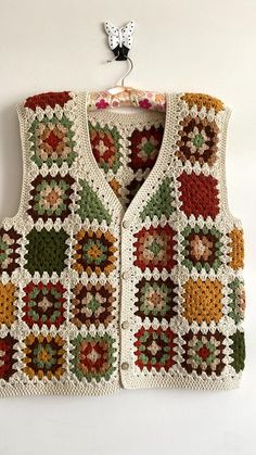 a crocheted vest hanging on a wall