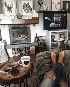 a person sitting on a couch with their feet propped up in front of a fireplace