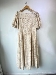 Doen Cream Floral Prairie Dress! 100% cotton with puffed short sleeves, side pockets, and a cute tie detail on the chest. It is unlined and has a side zipper. Made in India. Size XL, please refer to measurements. In excellent condition! Approx. Measurements: Underarm to Underarm: 20.5" Waist: 36" Length: 52.5" Spring Puff Sleeve Dress For Garden Party, Short Sleeve Dress With Gathered Neckline For Spring, Feminine Cotton Puff Sleeve Dress With Square Neck, Short Sleeve Dress With Gathered Neckline, Cotton Puff Sleeve Dress For Daywear, Cotton Puff Sleeve Dress With Square Neck For Daywear, Feminine Short Sleeve Dress With Gathered Neckline, Cotton Square Neck Puff Sleeve Dress For Daywear, Feminine Puff Sleeve Dress For Daywear