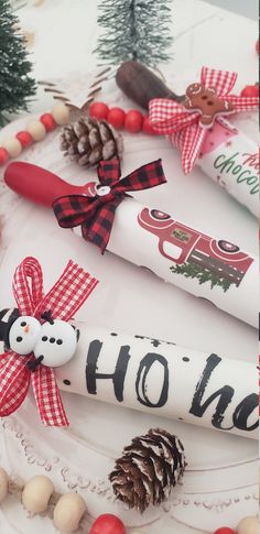 some christmas decorations are sitting on a white plate with red and black ribbon around them