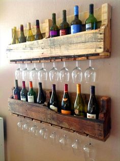 wine glasses and bottles are lined up on a wooden shelf in front of a wall mounted wine glass rack