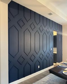 a dining room with blue walls and white chairs in front of the table is an art deco wall