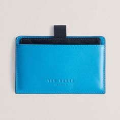 Ted Baker CODY Colour Block Bright Blue Leather Card Holder
Store your cards in one convenient yet secure place with this vibrant and ultra-stylish and compact RFID blocking card holder from Ted Baker. Slim enough to slip into any pocket, it is the ultimate accessory to keep you organised on the go!
Made from genuine bovine leather in a bright blue hue, the card holder has a tab at the top that you can pull up to reveal a sliding central compartment featuring 3 card slots. The interior is lined with a silky black chequered material and the Ted Baker logo is subtly embossed on the front for an extra touch of sophistication.
The cardholder contains an RFID blocker to ensure all your card details and personal information is kept safe.
Brilliantly presented in a Ted Baker branded giftbox, it m Baker Logo, I Love You Mum, Sports Wedding, City Dog, Oil Warmer, Bottle Jewelry, Leather Card Holder, Message In A Bottle, Baby Christening