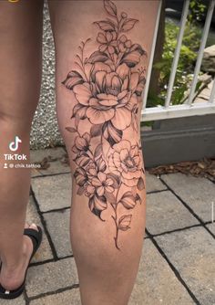 a woman's leg with flowers on it, and her legs are covered in black ink