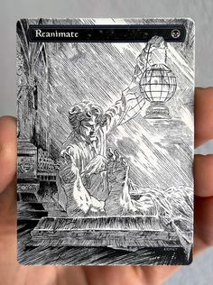 a person holding up a small card with a drawing on it's front cover