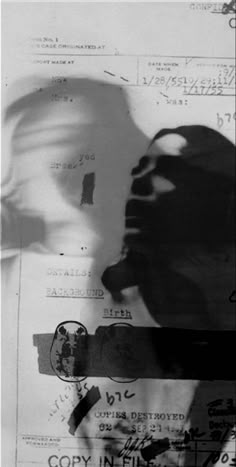 a black and white photo of a person's shadow on some paper with stamps