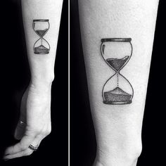 black and white photo of two tattoos with sand in the hourglasses on both forearms