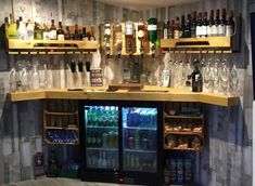 a bar with several shelves filled with bottles and glasses on top of it's sides