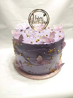 a birthday cake with purple frosting and gold sprinkles is shown on a white background