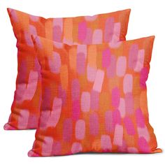 two orange and pink pillows sitting next to each other