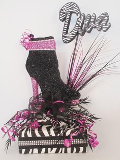 there is a zebra print shoe on top of a box with pink and black decorations