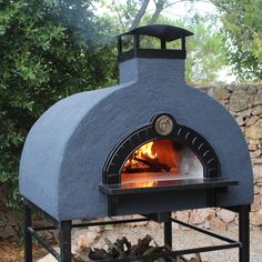 an outdoor pizza oven with fire in it