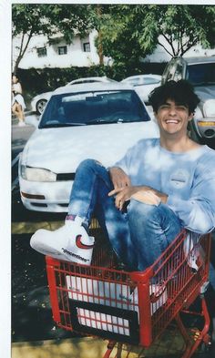 a man sitting in a red shopping cart