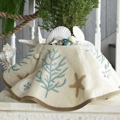 a potted plant sitting on top of a white table next to shells and starfish