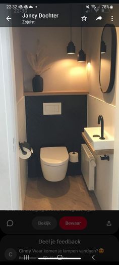 a toilet and sink in a small room with lights on the wall above it's mirror