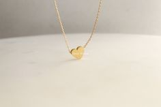 "Add a touch of elegance and sophistication to your jewelry collection with this beautiful brushed heart pendant necklace. Made with 18k gold dipping, this necklace features a unique and striking heart charm with a brushed finish that gives it a beautiful, soft texture. The heart is a symbol of love, affection, and connection, making this necklace a great gift for yourself or a loved one. The 16 inch chain is delicate and understated, allowing the heart charm to be the focal point of the piece. Elegant Heart-shaped Simple Jewelry, 14k Gold Minimalist Jewelry As Bridesmaid Gift, Minimalist Heart Charm Jewelry, Minimalist Jewelry With Heart Charm, Minimalist Heart Jewelry With Simple Design, Minimalist Heart Shaped Jewelry With Simple Design, Minimalist Heart-shaped Jewelry With Simple Design, Minimalist Tarnish Resistant Heart Pendant Jewelry, Minimalist Tarnish-resistant Heart Pendant Jewelry