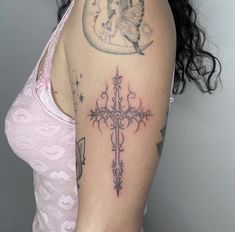 a woman with a cross tattoo on her arm