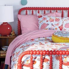 a bed with red headboard and pink bedspread