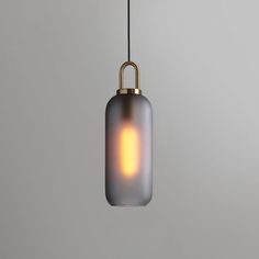 a light that is hanging from a wire on the ceiling with a gray wall in the background