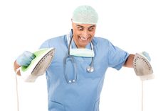 a male doctor in scrubs is holding two irons