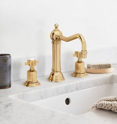 a bathroom sink with two faucets and soap dispenser