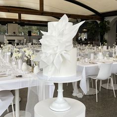 a large white cake sitting on top of a table covered in plates and napkins