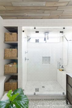 a walk in shower sitting next to a bath tub and sink under a wooden ceiling