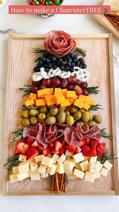 a christmas tree made out of cheeses, olives and meats on a tray