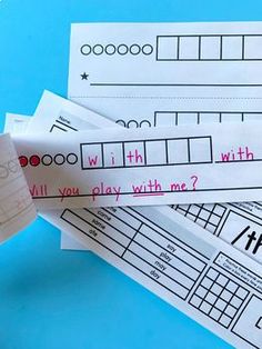 some paper with writing on them sitting on top of a blue table next to scissors