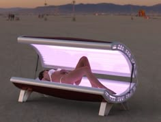 a woman laying on top of a bench in the middle of an empty desert area