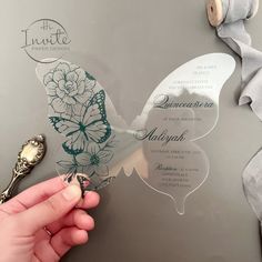 a person cutting out a butterfly shaped wedding card