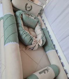 a baby's crib is decorated with green and white pillows