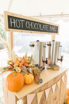 a hot chocolate bar with pumpkins and other decorations