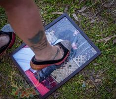 a person standing on top of a mirror with their feet in the ground and one foot sticking out