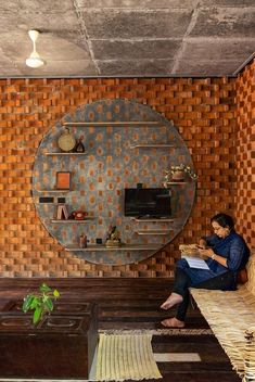 a woman sitting on a bench in front of a wall with circles painted on it