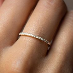 a woman's hand with a diamond ring on her left hand and the middle finger