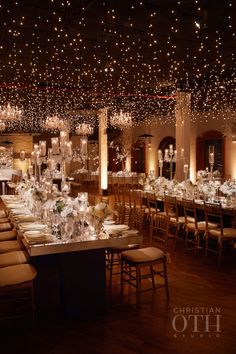 a banquet hall with tables, chairs and chandeliers on the ceiling is lit by lights