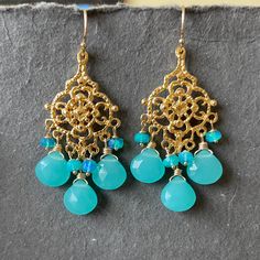 These are rich and elegant detailed chandeliers that are 18K gold that is plated over 925 sterling. They are very sturdy and although they are delicate looking they are nice and solid. A true heirloom. I paired them with beautiful blue faceted chalcedony and opals that are so beautiful and reflective. Just look at what happens to them in the light. Gold Filled French earwires, but if you prefer leverback just choose the upgrade . The entire length of the earrings are apprx 2 1/8”. **leverback up Gold Chalcedony Dangle Earrings, Elegant Handmade Chalcedony Earrings, Handmade Gold Earrings With Chalcedony, Bohemian Gold Chandelier Earrings With Gemstones, Colorful Jewelry, Blue Chalcedony, Chandelier Earrings, So Beautiful, Beautiful Blue