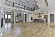 an empty living room with wood floors and stairs