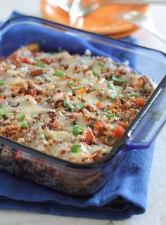 a casserole dish with meat and vegetables in it on a blue cloth next to a fork