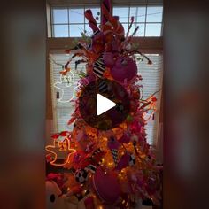 a decorated christmas tree in front of a window