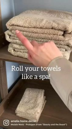 a person is pointing at towels stacked on top of each other with the words roll your towels like a spa