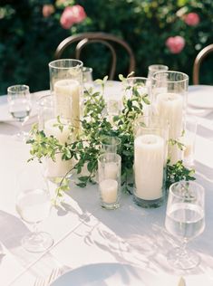 the table is set with candles and greenery