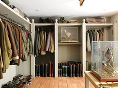 a walk in closet filled with lots of clothes and boots on the shelf next to shoes