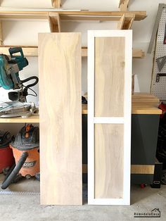 two unfinished doors in a garage with tools on the table and workbench behind them