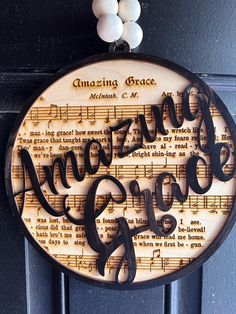 a sign that says amazing grace hanging on a door with musical notes in the background