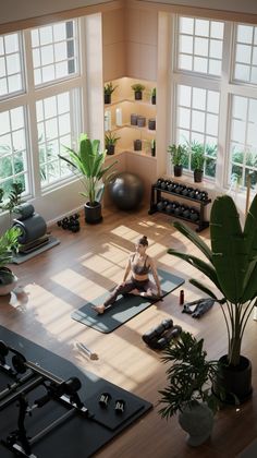 a woman is sitting on a yoga mat in the middle of a room with windows