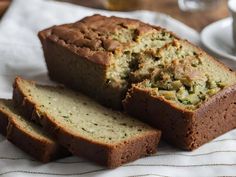 slices of zucchini bread sitting on top of a white towel next to a cup and saucer