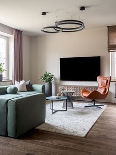 a living room filled with furniture and a flat screen tv mounted on the wall above it